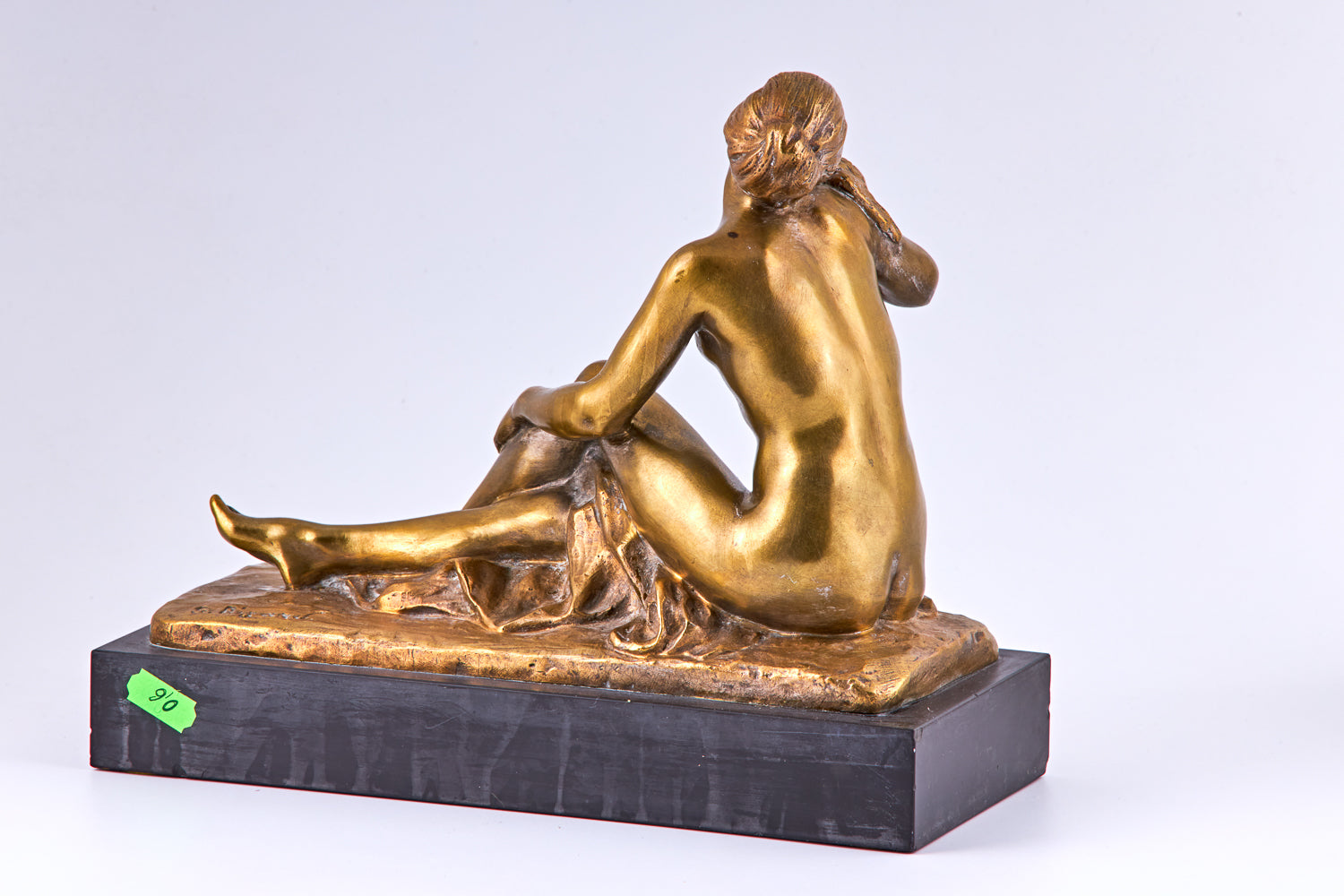 Una escultura de bronce bañada en oro de principios del siglo XX que representa a una mujer desnuda y un pájaro.