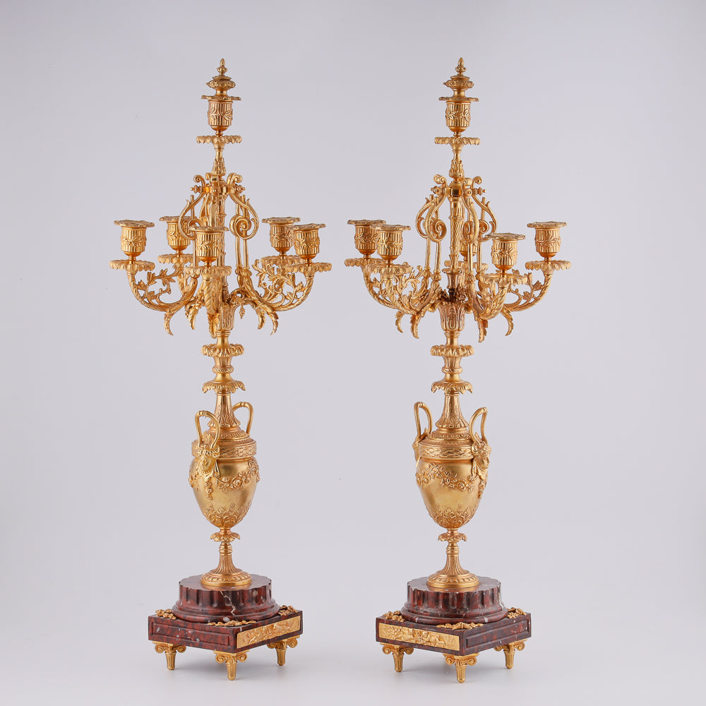 Pair of antique candelabras on a marble plinth