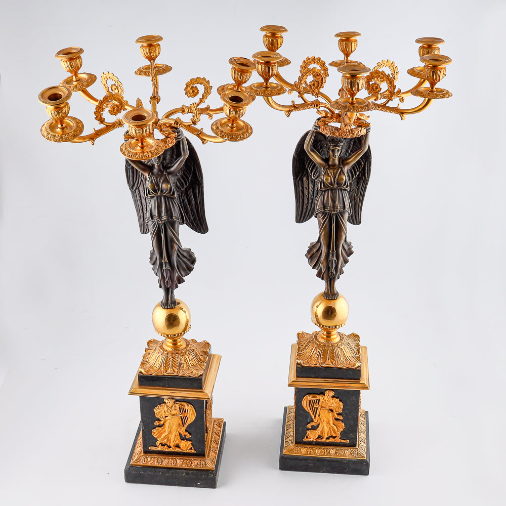 Four antique candelabras with a statue of winged victory