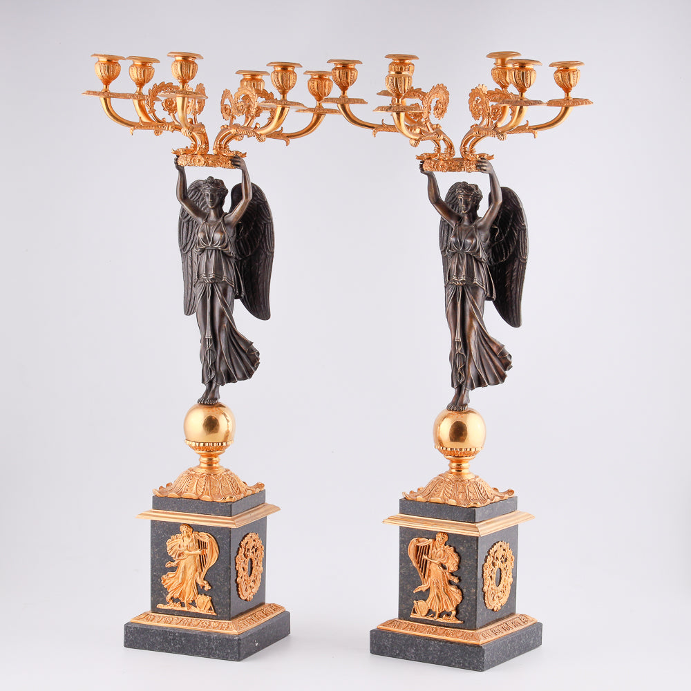 Four antique candelabras with a statue of winged victory