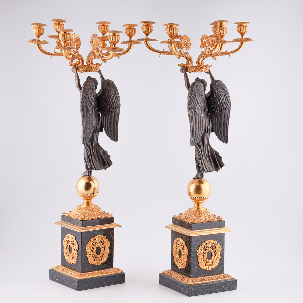 Four antique candelabras with a statue of winged victory