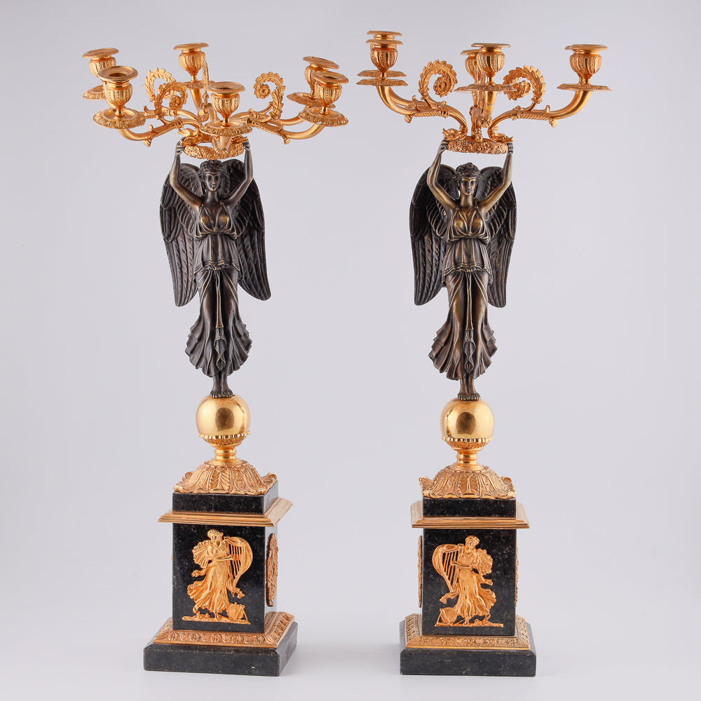Four antique candelabras with a statue of winged victory