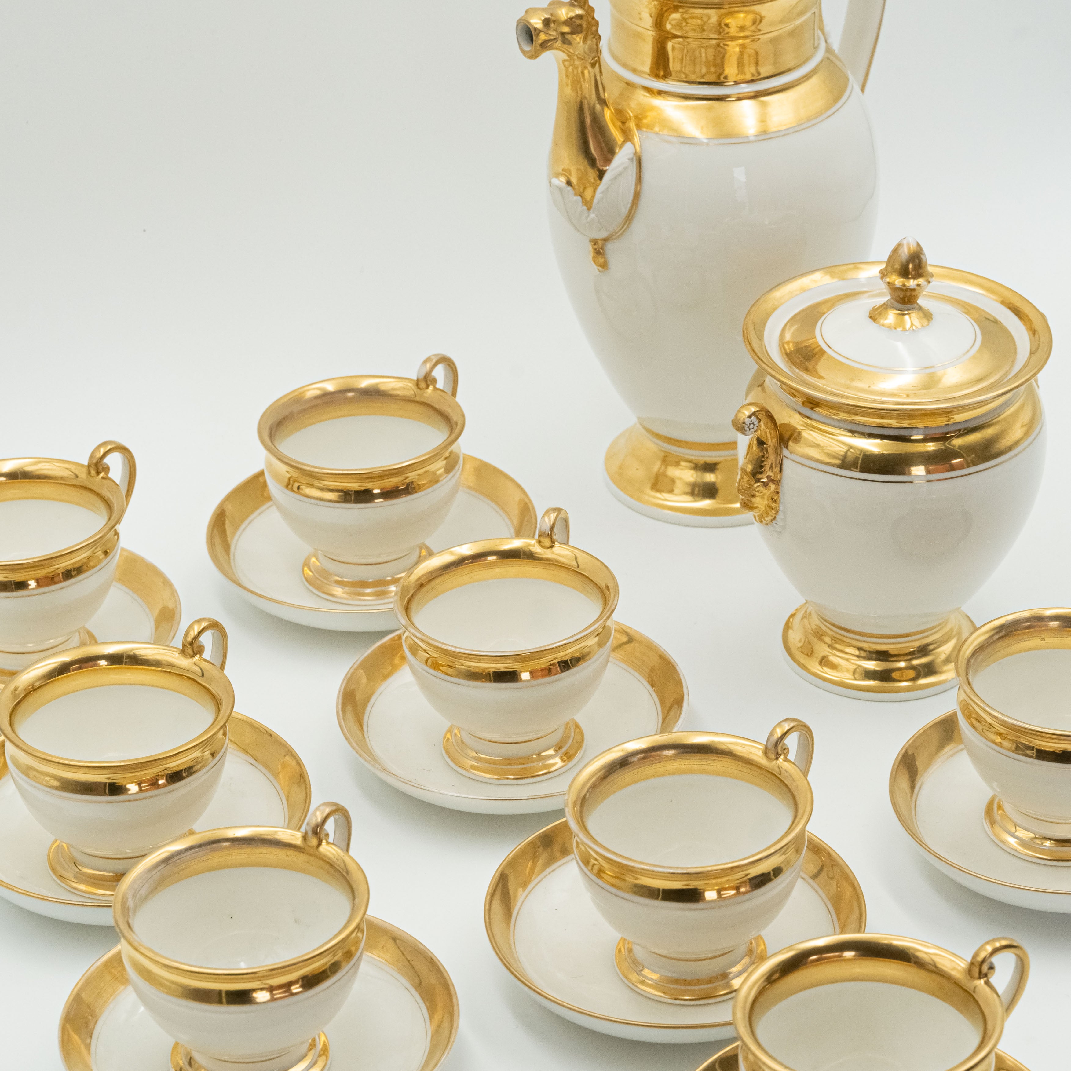 Late 19th century European porcelain coffee set for 8 persons worked out with a delicate relief that forms Mascarons